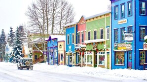 A colorful street lined with various shops and buildings, including a blue building with a sign that reads "PooHscorner."