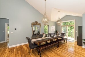 Comedor con una larga mesa de madera, bancos y un candelabro.