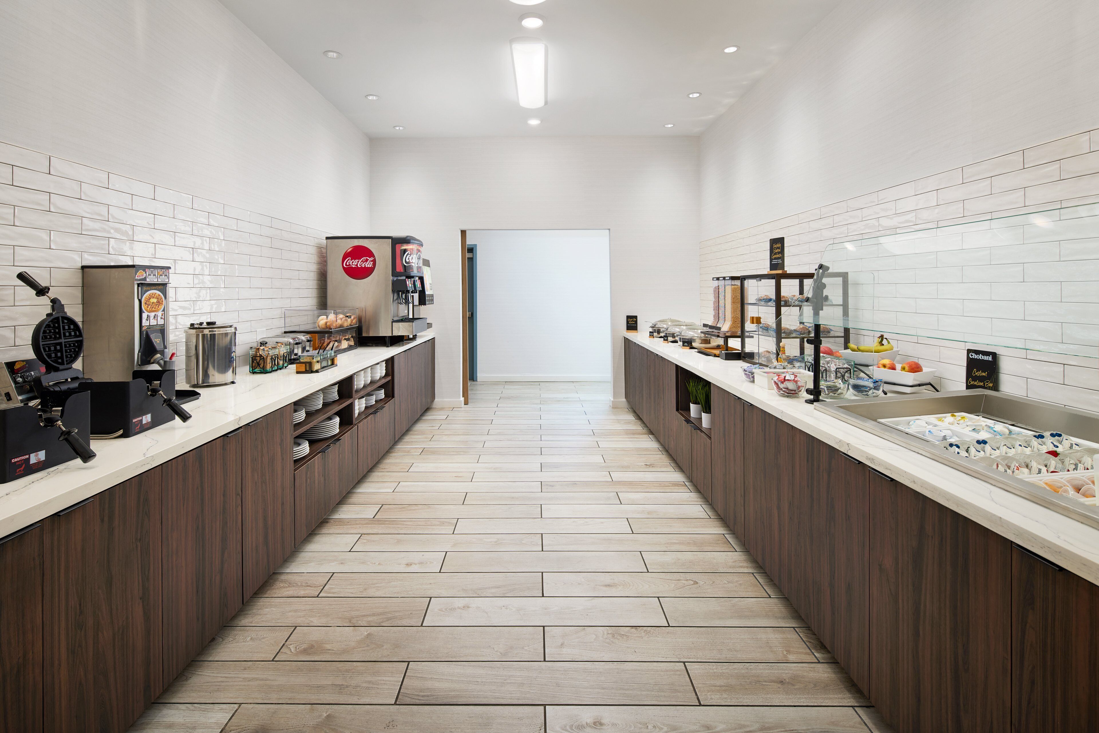 Une cuisine moderne dotée d’un long comptoir, de machines à café et d’une grande variété de produits alimentaires.