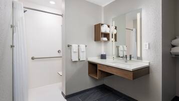 Une salle de bain moderne avec une douche, un meuble-lavabo et un grand miroir.