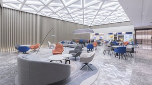 Un hall espacioso con modernas áreas de descanso y un techo alto con diseños geométricos.