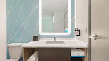 A bathroom with a white sink, a mirror, and a towel rack.