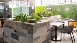Un espace extérieur aménagé avec des jardinières en pierre et des plantes vertes.