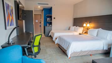 Una habitación de hotel con dos camas, un escritorio, una silla y un televisor.