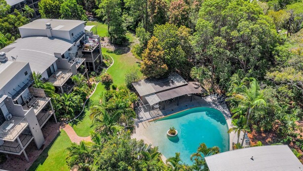 A modern house with a swimming pool surrounded by lush greenery. - Baden 28 - Rainbow Shores. Top Floor Unit. Air conditioned. Walk to Beach (Rainbow Beach)