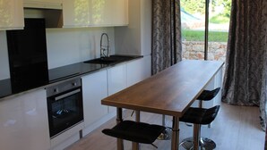 Una cucina moderna con mobili bianchi, un piano di lavoro nero e un tavolo da pranzo in legno con sedie nere.