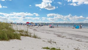 Una playa con gente, sombrillas y tiendas de campaña.
