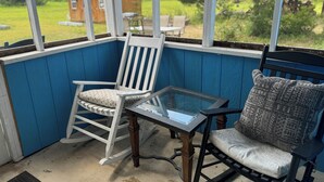 A blue porch with a rocking chair and a cushioned bench. - Book Fast! Top-Rated 5★ Cottage Near Carolina Beach—Private, Peaceful, Perfect (Wilmington)