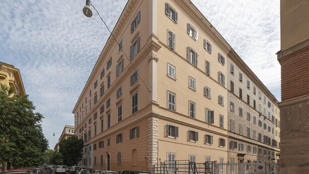 Un immeuble à plusieurs étages, de style architectural classique, caractérisé par une façade symétrique avec des fenêtres régulièrement espacées et une entrée centrale.