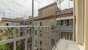 Un immeuble à plusieurs étages doté de balcons, d’une rambarde en métal et offrant une vue sur les bâtiments adjacents.
