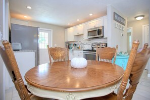 Enjoy cooking and dining in this kitchen with a refrigerator, microwave, oven, and dining table for four.
