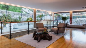 A spacious balcony with a wooden floor, two armchairs, a round coffee table, and a sofa. - Casa Quinta Do Rio (Braga)