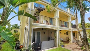 A two-story house with a balcony, a covered patio, and a garden with tropical plants. - 3 OR 6 bdrms  Villa - 1 minute from the beach ADD GUESTHOUSE (Boca Raton)