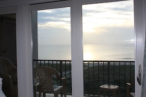 Enjoy breathtaking sea views from this balcony with a table and two chairs.