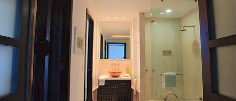 Un baño moderno con una bañera grande, una ducha con cerramiento de vidrio y un lavamanos con lavabo.