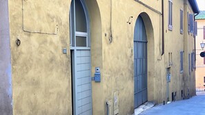 A yellow building with arched windows and doors, a narrow street, and a mailbox. - LOFT 22 - Moderno a due passi da Piazza del Campo (Siena)