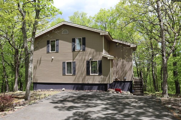 A two-story house with a front porch and a staircase leading to the second floor. - Cozy Retreat in the Poconos Mountains (Bushkill)