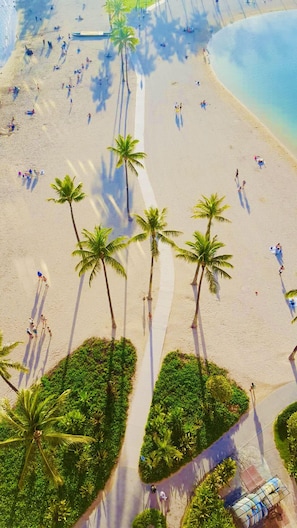 An aerial view of a beach with palm trees, people, and a clear sky. - BIG ALOHA & AWESOME VIEW AT THIS HAWAIIAN HOME! (Honolulu)