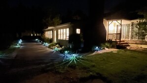Een woonstraat 's nachts, huizen verlicht door buitenverlichting.