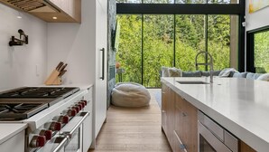 Une cuisine moderne dotée d’une grande fenêtre, d’une cuisinière et d’un évier.