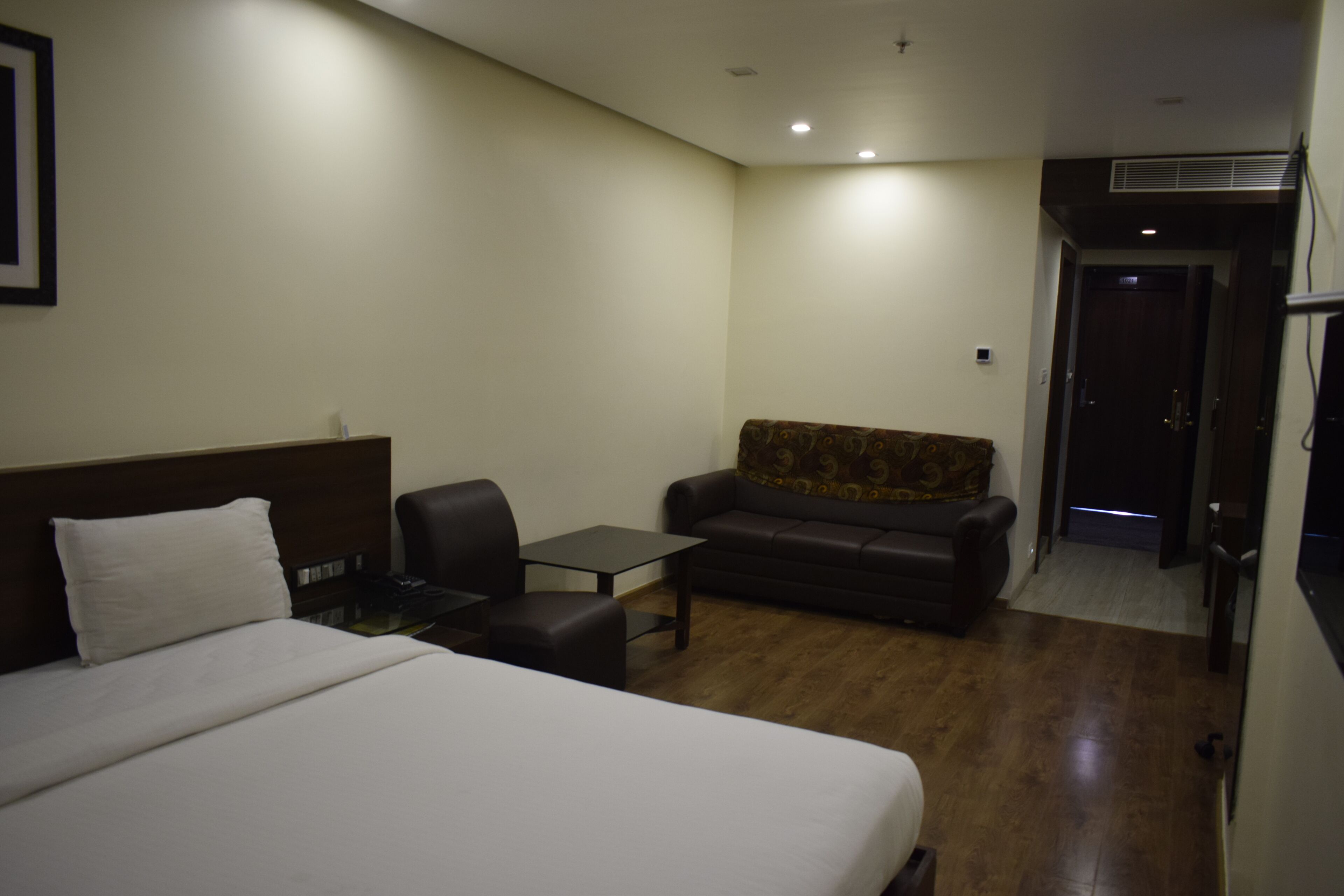 Una habitación de hotel con una cama grande, un sofá, una mesita y un escritorio.