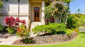A two-story house with a stone retaining wall, a front door, and a small porch. - I.P.M PRESENTS: HOOLEI 93-1: 3 BEDROOMS + OFFICE. FLEXIBLE CANCELATION POLICY (Kihei)