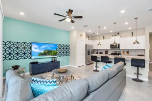 A modern kitchen with white cabinets, a central island, and pendant lighting. - Toy Story & Disney Rooms • Private Pool • Lazy River • Near Disney (Davenport)