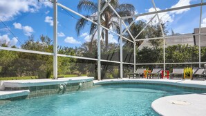 Une piscine à l’eau d’un bleu cristallin, entourée d’une structure blanche, avec des arbres en arrière-plan.