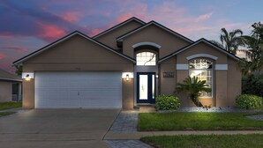 Une maison d’habitation avec un garage, une porte d’entrée dotée d’une fenêtre et une pelouse bien entretenue.