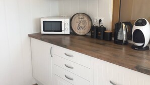 A kitchen with white cabinets, a microwave, a kettle, and a coffee maker on the counter. - 2 Bed Penthouse - Sleeps 4 - Pool - Sea Views (Finestrat)