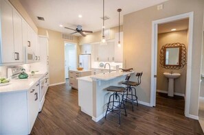 Enjoy cooking in this well-equipped kitchen with a central island, microwave, oven, and sink.