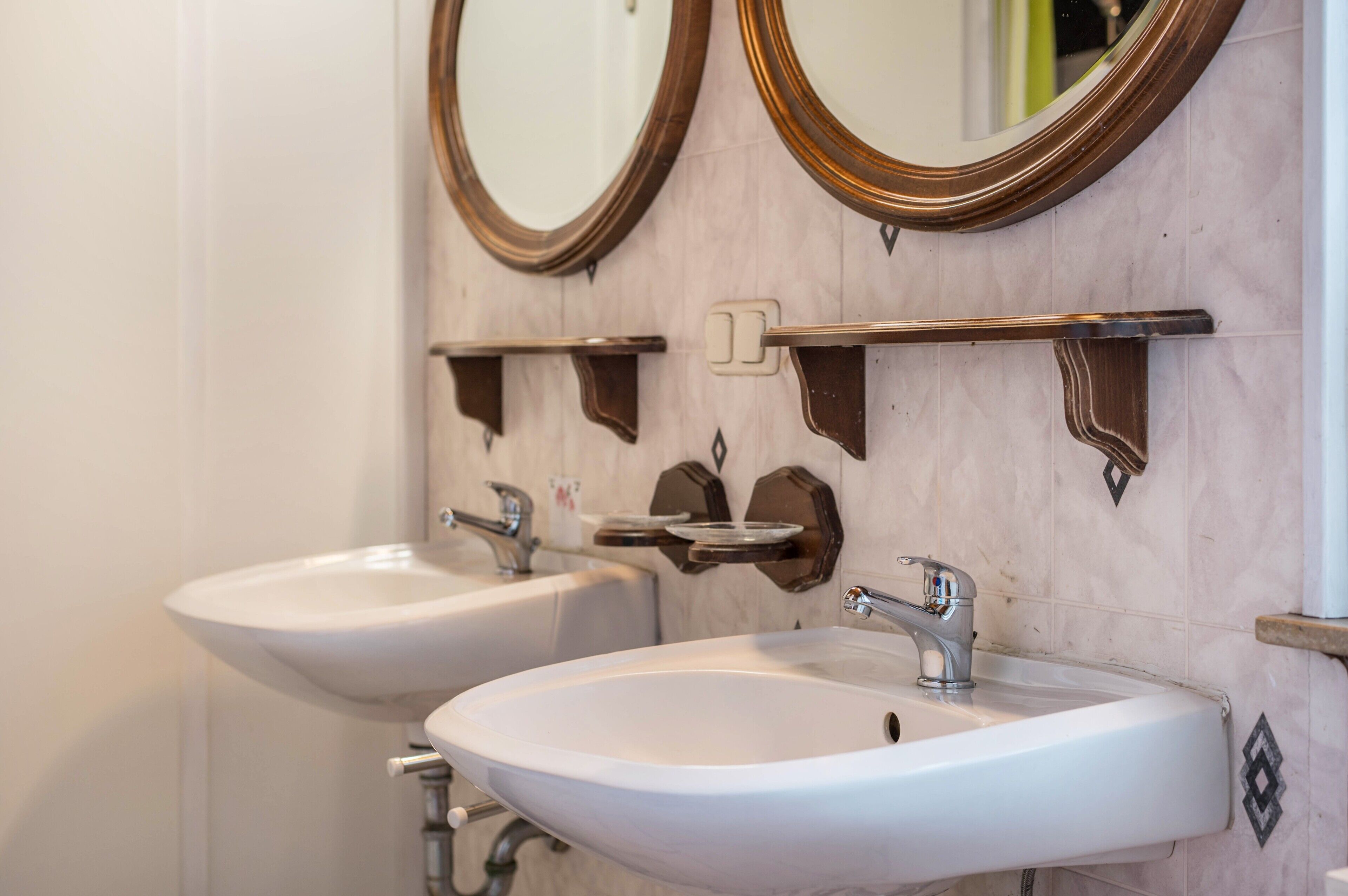 A bathroom with two sinks, a mirror, and a towel rack.