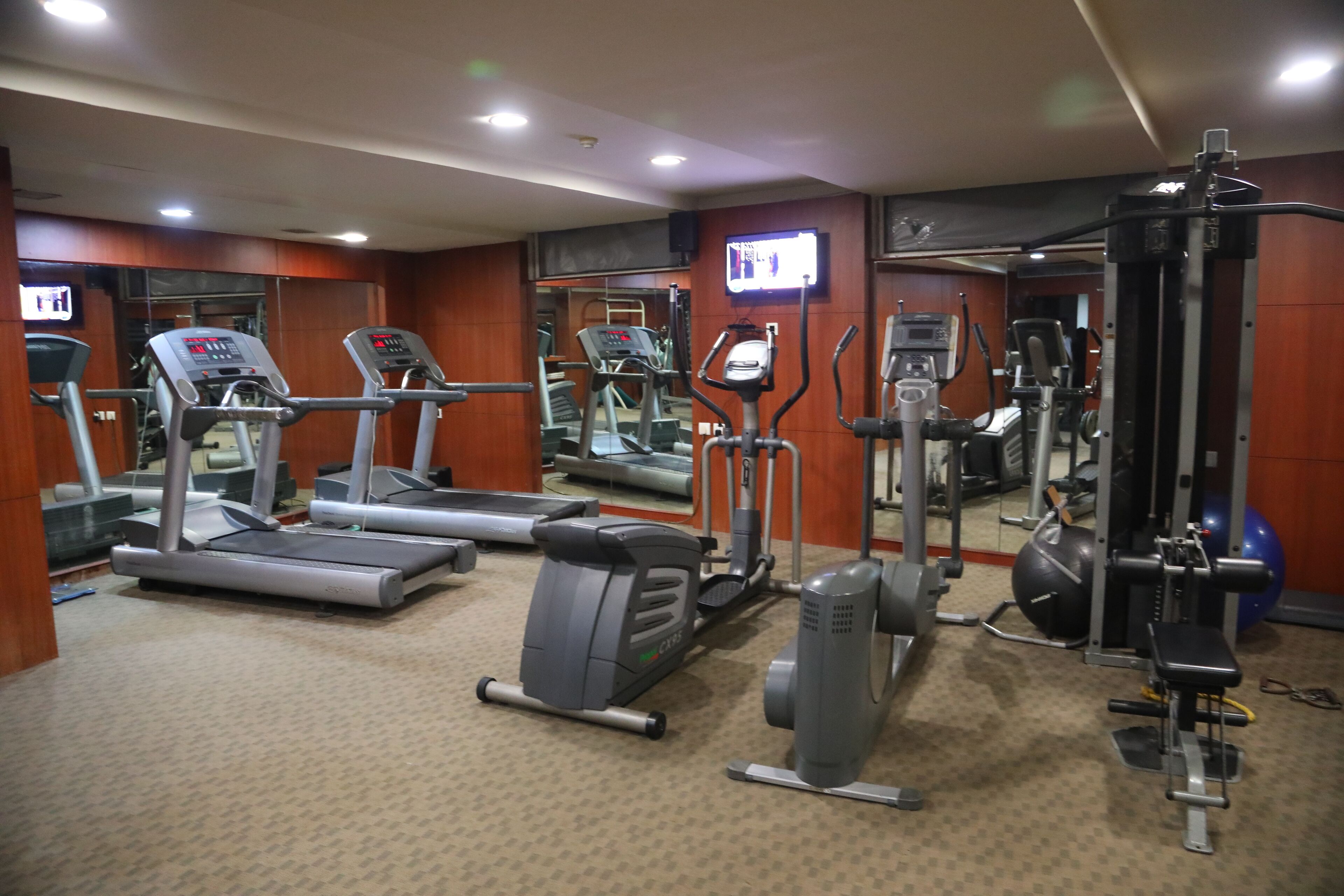 A gym with treadmills, elliptical machines, and weight equipment.