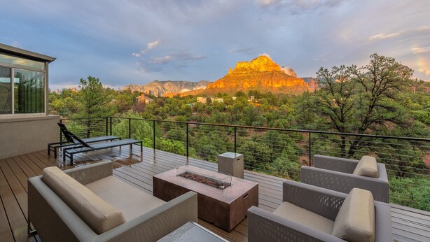 Una terraza con mobiliario exterior, un brasero y vistas a una cordillera.