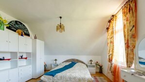 Una habitació amb un llit, un armari, un escriptori i un mirall.