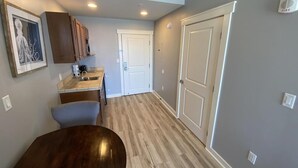 A compact kitchen with a dining table, a microwave, and cabinets. - Beautiful Beachfront luxury living at its best (Panama City Beach)