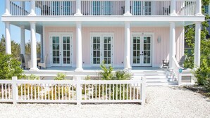 Une maison à deux étages avec un porche couvert, des colonnes blanches et le numéro « 33 » sur la porte.