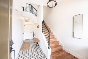 A staircase with wooden steps and black railings leading to an upper floor.