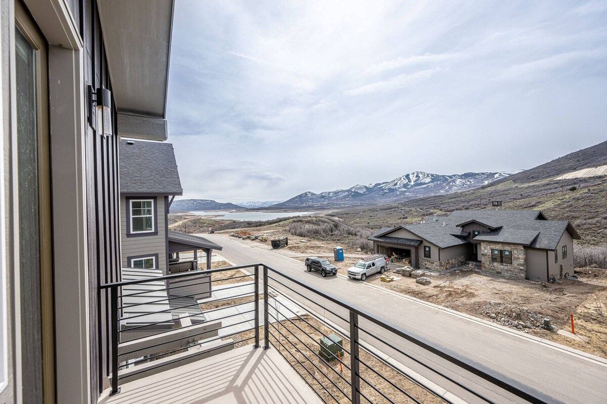 A residential area with a balcony overlooking a road and distant mountains.