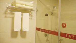 A bathroom with a glass shower door, a towel rack with folded towels, and a red sign with Chinese characters. - Huitang Zilongwan Hot Spring Holiday Hotel (Changsha)