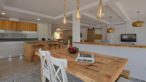 A modern kitchen with wooden cabinets, a central island, and pendant lighting.