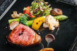 A plate of food with various vegetables and a piece of meat.