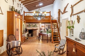 A rustic interior with a loft bed, wooden furniture, and a fireplace.