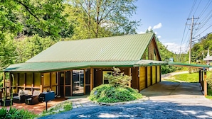 Eine Holzhütte mit überdachter Veranda und Sitzbereich im Freien.