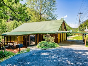 A wooden cabin with a covered porch and outdoor seating area.