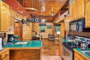A kitchen with wooden cabinets, a dining area, and a fireplace.