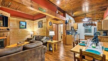 A cozy cabin interior with a living room, dining area, and kitchen.
