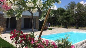 Piscina cercada por vegetação exuberante e plantas floridas.