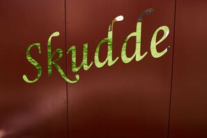Eine Wand mit der stilisierten Aufschrift "skudde" in Grün.