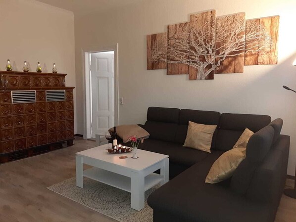 A living room with a sofa, a coffee table, a cabinet, and a door.